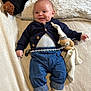 baby, smiling, dimples, cardigan, denim_pants, plush_toy, pacifier, blanket, cozy, infant, cute, lying_down, soft_toy, rolled_pants, socks, happy, indoors, child, comfort, toddler