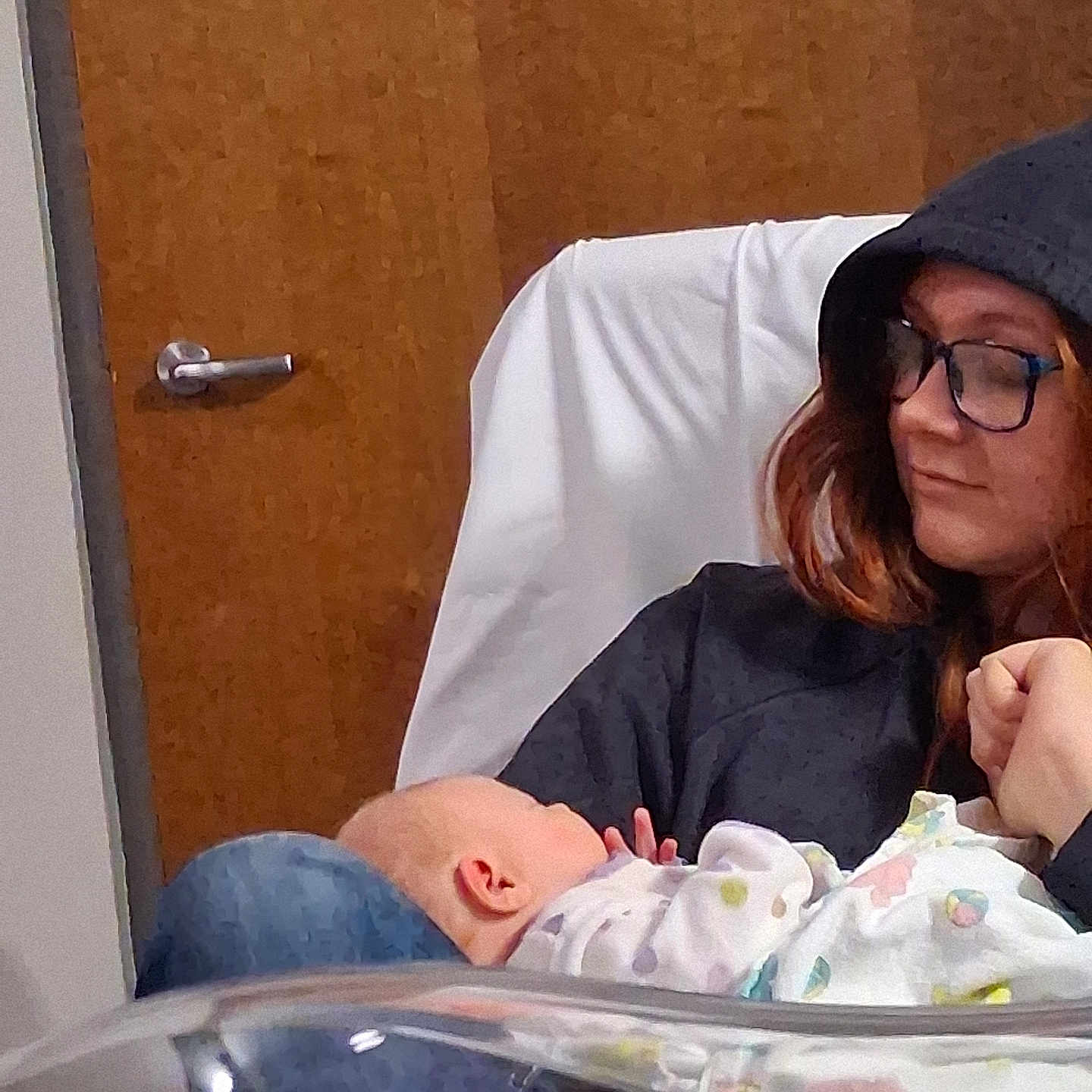 Hailey is registered to the contest to win money with this photo: baby, blanket, caring, casual, comfort, door, glasses, holding, hoodie, human, indoor, infant, love, parenting, person, portrait, resting, seated, warmth, wood