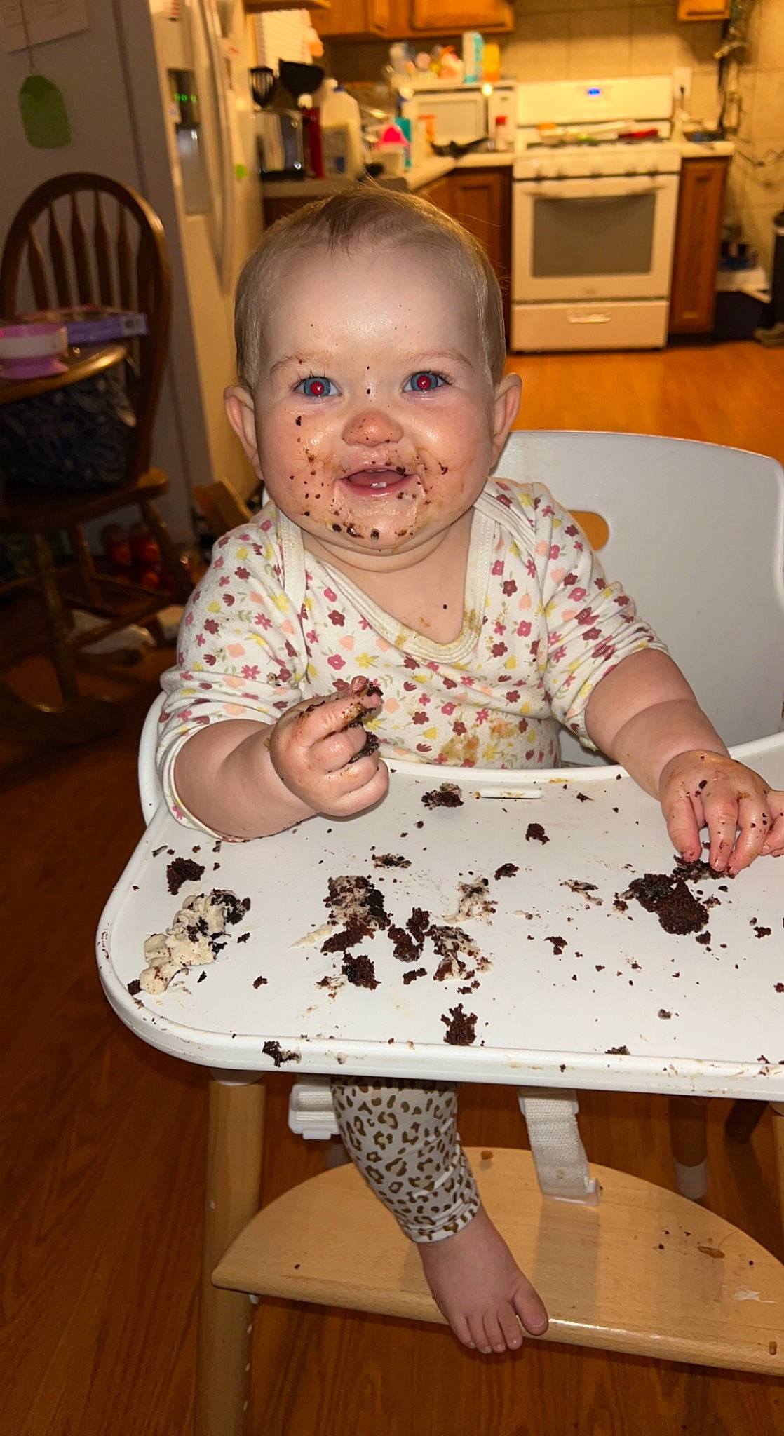 Maisie is registered to the contest to win money with this photo: arm, baby, baked_goods, buttercream, cake, cake_decorating, chair, child, dessert, eye, flooring, food, fun, indoor_games_and_sports, pattern, person, sitting, smile, sugar_cake, sweetness