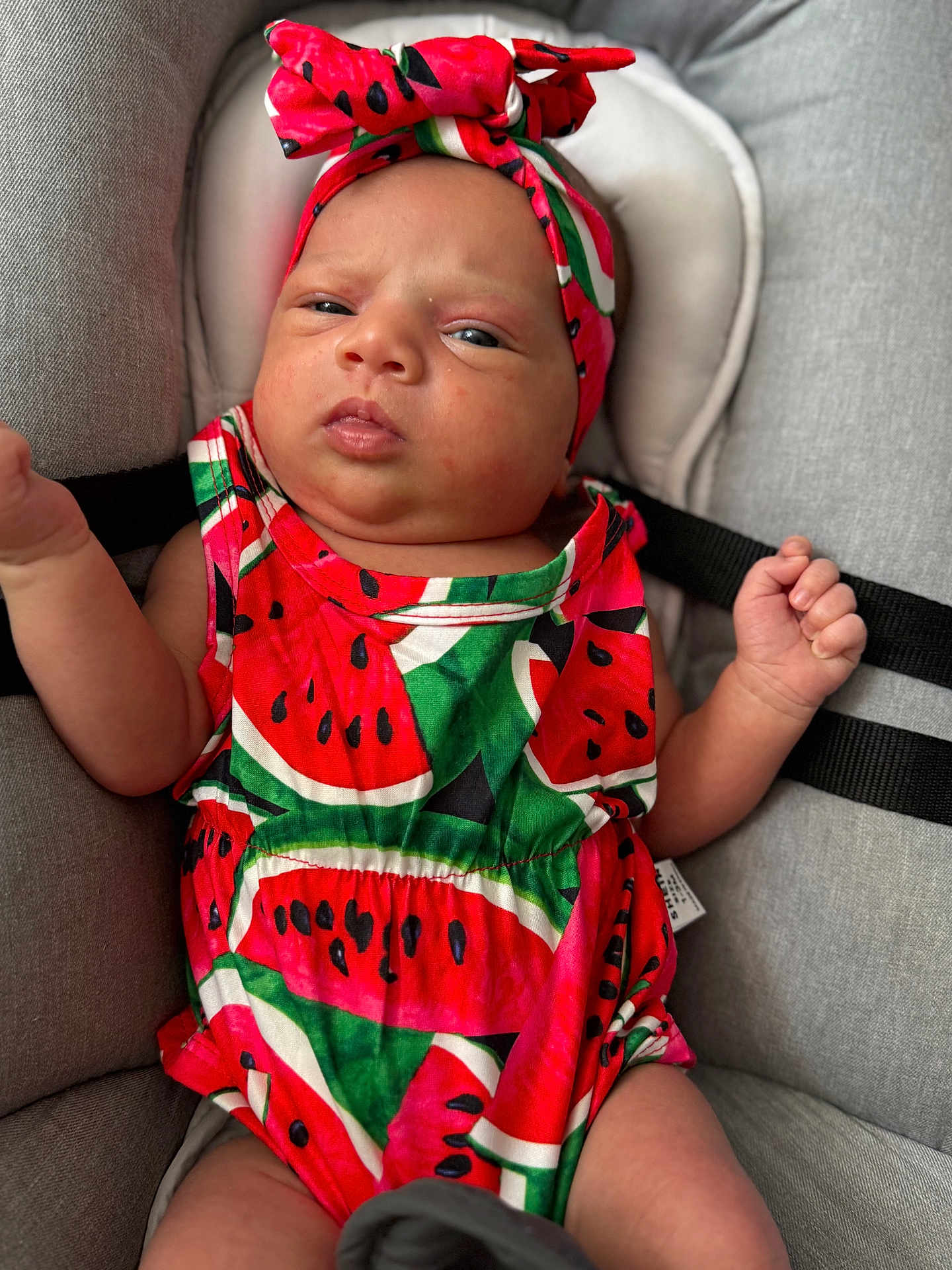 Inaya a rejoint le concours — aidez-le/la à gagner de superbes lots ! baby, child, infant, watermelon_outfit, headband, cushion, seat, clothing, cute, portrait, indoor, skin, face, hands, expression, colorful, patterned_clothing, sitting, young, adorable