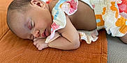Inaya participe au concours pour gagner de l'argent avec cette photo : baby, sleeping, infant, colorful_clothing, blanket, orange, texture, closeup, peaceful, rest, child, skin, hand, face, portrait, soft_light, indoors, cute, newborn, cozy