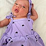 baby, infant, child, purple_dress, headband, heart_pattern, lying_down, curious_expression, cute, adorable, soft_background, close_up, portrait, skin, face, eyes, mouth, clothing, newborn, person