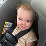 toddler, car_seat, child, seatbelt, smile, face, hair, clothing, safety, infant, baby, seat, straps, cute, indoors, person, young_child, expression, cheeky, playful