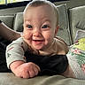 James is registered to the contest to win money with this photo: baby, smile, happy, infant, couch, socks, pikachu, person, indoors, clothing, cute, child, playful, face, hand, footwear, home, window, fabric, cozy
