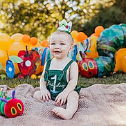 Kohen joined the competition — help win amazing prizes! baby, balloons, birthday, blanket, caterpillar, celebration, child, colorful, crown, first_birthday, grass, green_clothing, happy, nature, outdoor, party, playful, smile, sunlight, toy