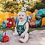 baby, balloons, birthday, blanket, caterpillar, celebration, child, colorful, crown, first_birthday, grass, green_clothing, happy, nature, outdoor, party, playful, smile, sunlight, toy