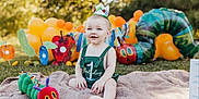 Kohen is registered to the contest to win money with this photo: baby, balloons, birthday, blanket, caterpillar, celebration, child, colorful, crown, first_birthday, grass, green_clothing, happy, nature, outdoor, party, playful, smile, sunlight, toy