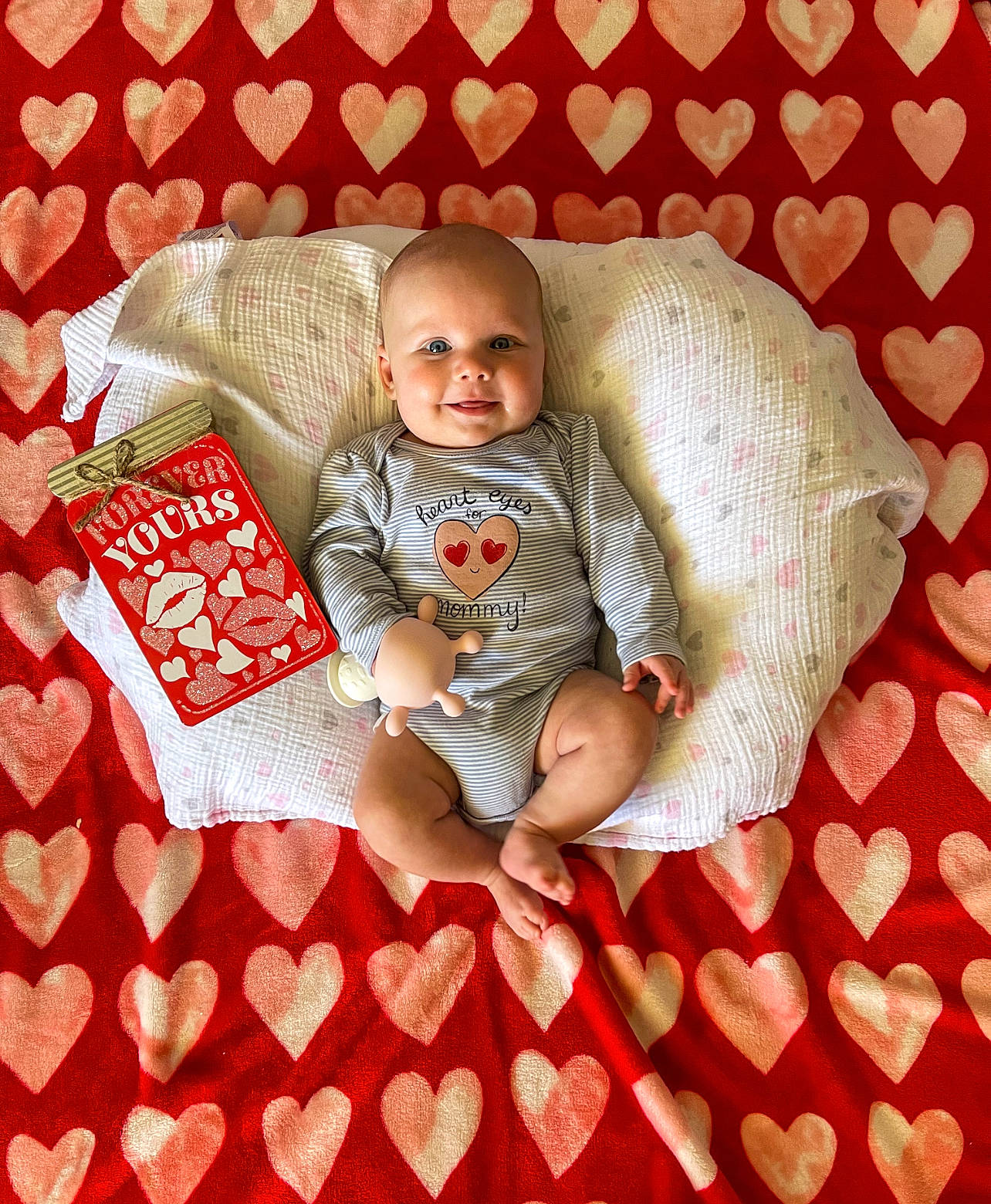 Weston is registered to the contest to win money with this photo: baby, baby_products, baby_toddler_clothing, bedding, carmine, child, comfort, flooring, font, happy, joy, linens, pattern, person, red, room, sitting, sleeve, smile, t_shirt