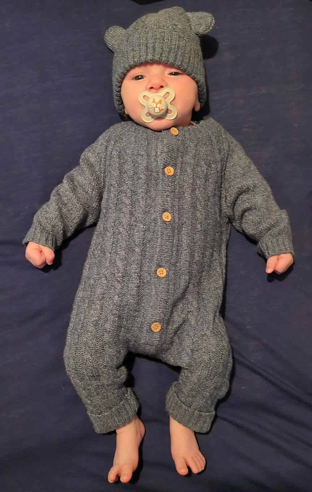 Tobias is registered to the contest to win money with this photo: baby, bare_feet, buttoned_outfit, child, cozy, cute, gray_outfit, hat_with_ears, indoor, infant, knitted_clothing, looking_at_camera, lying_down, one_person, pacifier, portrait, resting, small_hands, soft_texture, warm_clothing
