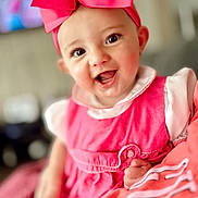 Blakeleigh is registered to the contest to win money with this photo: baby, child, smiling, pink_bow, pink_dress, indoor, portrait, happy, cute, infant, headwear, face, eyes, hand, soft_focus, person, clothing, skin, cheeks, closeup