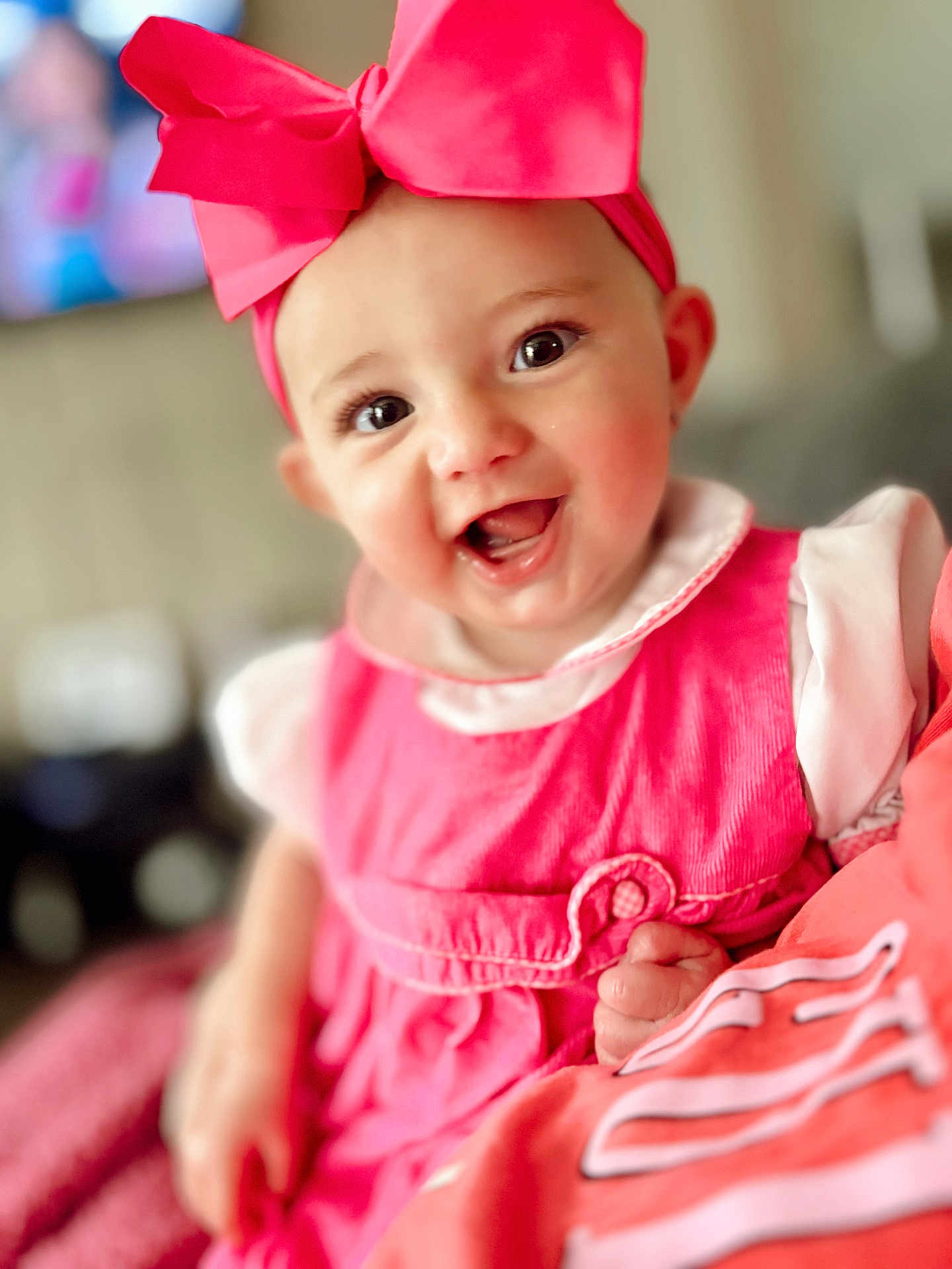 Blakeleigh is registered to the contest to win money with this photo: baby, child, smiling, pink_bow, pink_dress, indoor, portrait, happy, cute, infant, headwear, face, eyes, hand, soft_focus, person, clothing, skin, cheeks, closeup