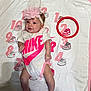 Raelynn Grace is registered to the contest to win money with this photo: baby, infant, headband, flower, pink, nike, onesie, blanket, numbers, sneakers, red_circle, smiling, cute, child, laying_down, clothing, footwear, playful, indoor, portrait