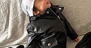 Dylan participe au concours pour gagner de l'argent avec cette photo : toddler, child, leather_jacket, bandana, couch, patterned_fabric, smile, tongue_out, casual_clothing, indoor, cute, fashion, sitting, person, young_child, happy, headwear, pants, socks, playful