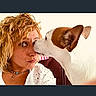 Guizmo a rejoint le concours — aidez-le/la à gagner de superbes lots ! woman, dog, pet, face, kiss, curly_hair, white_clothing, brown_and_white_dog, indoor, portrait, affection, close_up, expression, necklace, playful, cute, animal, human, interaction, love