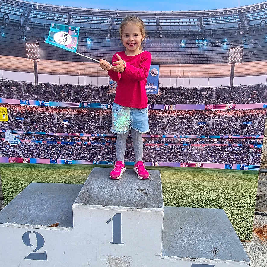 Ana participe au concours pour gagner de l'argent avec cette photo : architecture, arena, building, child, clothing, face, female, field, footwear, girl, head, outdoors, pants, people, person, photography, portrait, shoe, shorts, stadium