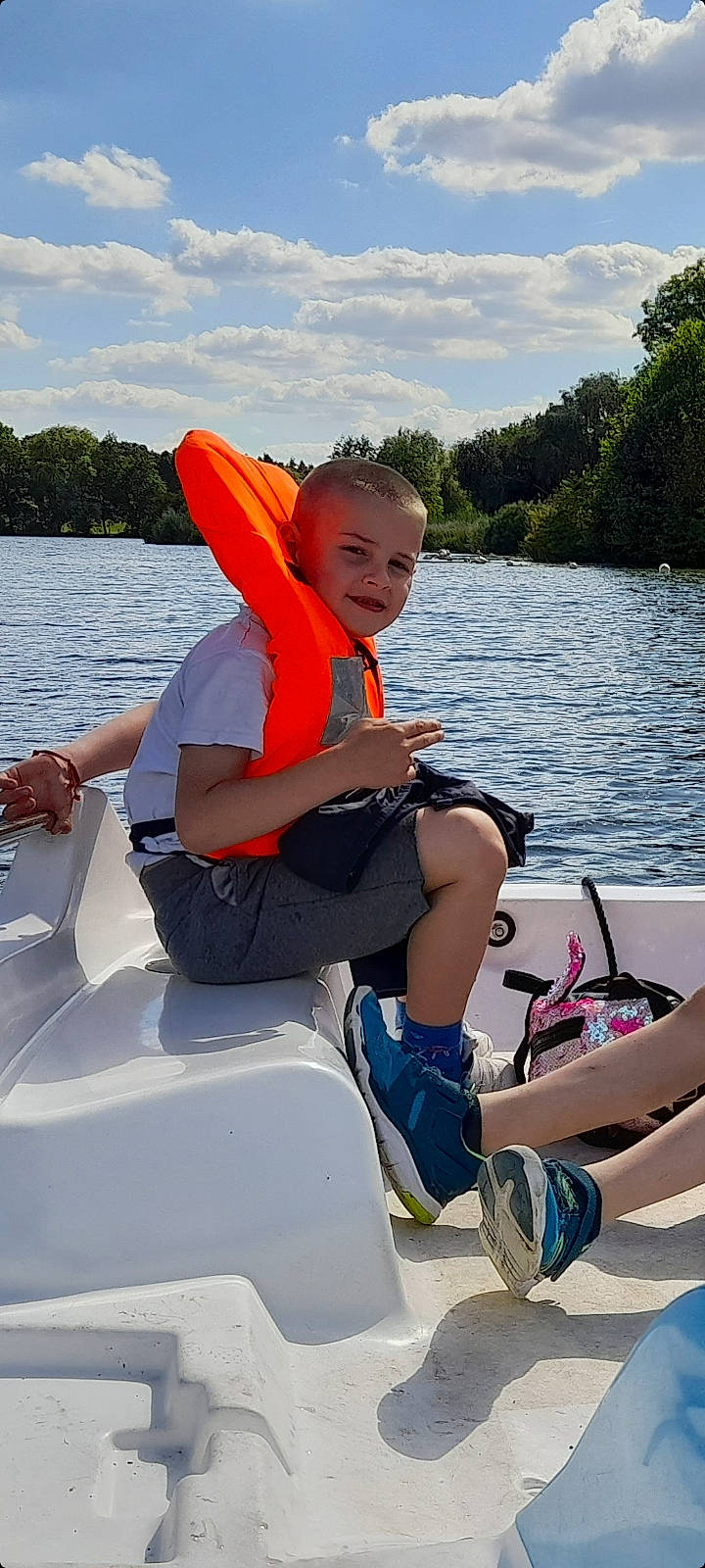 Remus a rejoint le concours — aidez-le/la à gagner de superbes lots ! boat, boating, boats_and_boating_equipment_and_supplies, cloud, fun, joy, lake, leisure, lifejacket, outdoor_recreation, person, personal_protective_equipment, recreation, shorts, skiff, sky, thigh, tree, vehicle, water