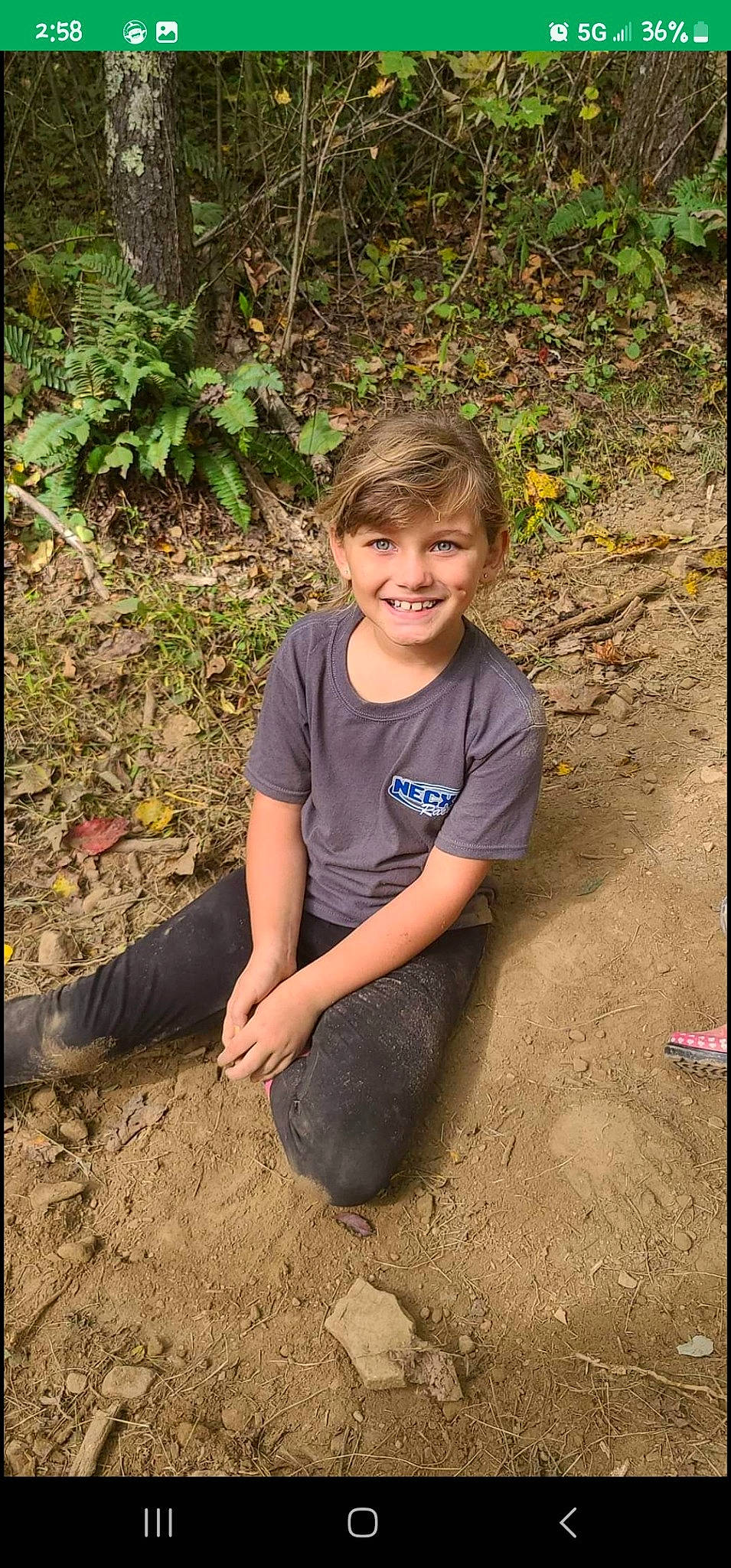 Emily joined the competition — help win amazing prizes! child, forest, fun, grass, happy, joy, jungle, landscape, leisure, people_in_nature, person, plant, play, rock, sand, sitting, smile, soil, t_shirt, tree