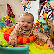 Casey joined the competition — help win amazing prizes! baby, child, smile, indoor, activity_center, toy, play, happy, infant, clothing, colorful, face, hands, window, furniture, radiator, table, kitchen, floor, room