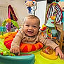 baby, child, smile, indoor, activity_center, toy, play, happy, infant, clothing, colorful, face, hands, window, furniture, radiator, table, kitchen, floor, room