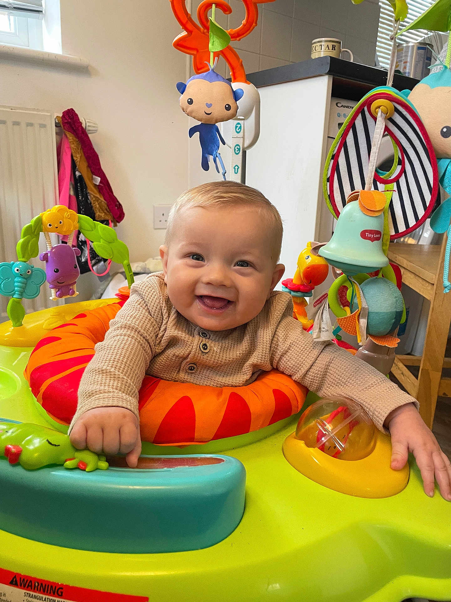 Casey joined the competition — help win amazing prizes! baby, child, smile, indoor, activity_center, toy, play, happy, infant, clothing, colorful, face, hands, window, furniture, radiator, table, kitchen, floor, room