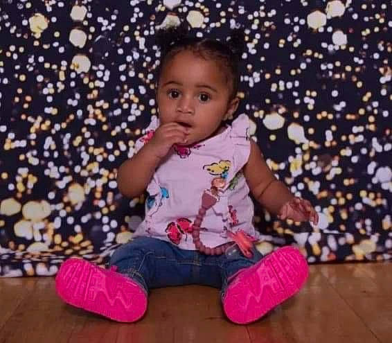Faith Iyanna is registered to the contest to win money with this photo: baby, baby_toddler_clothing, beauty, cheek, child, comfort, event, face, facial_expression, flooring, fun, happy, hardwood, magenta, pattern, person, purple, sitting, sleeve, toddler