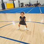 Jemma joined the competition — help win amazing prizes! child, girl, gymnasium, cheerleader, sports, basketball_hoop, blue_mat, wooden_floor, bleachers, group, people, indoor, athletic, pose, smile, curly_hair, white_shoes, black_outfit, team, recreation
