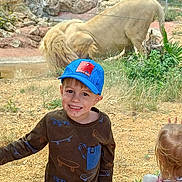 Kyron a rejoint le concours — aidez-le/la à gagner de superbes lots ! child, boy, smiling, cap, spiderman, lion, zoo, glass, enclosure, rocks, grass, toy, girl, standing, outdoor, nature, animal, fence, happy, casual_clothing