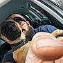 dog, man, finger, car_interior, glasses, beard, collar, close_up, selfie, window, seat, tattoo, casual_clothing, pet, indoor, face, animal, brown, black, nose