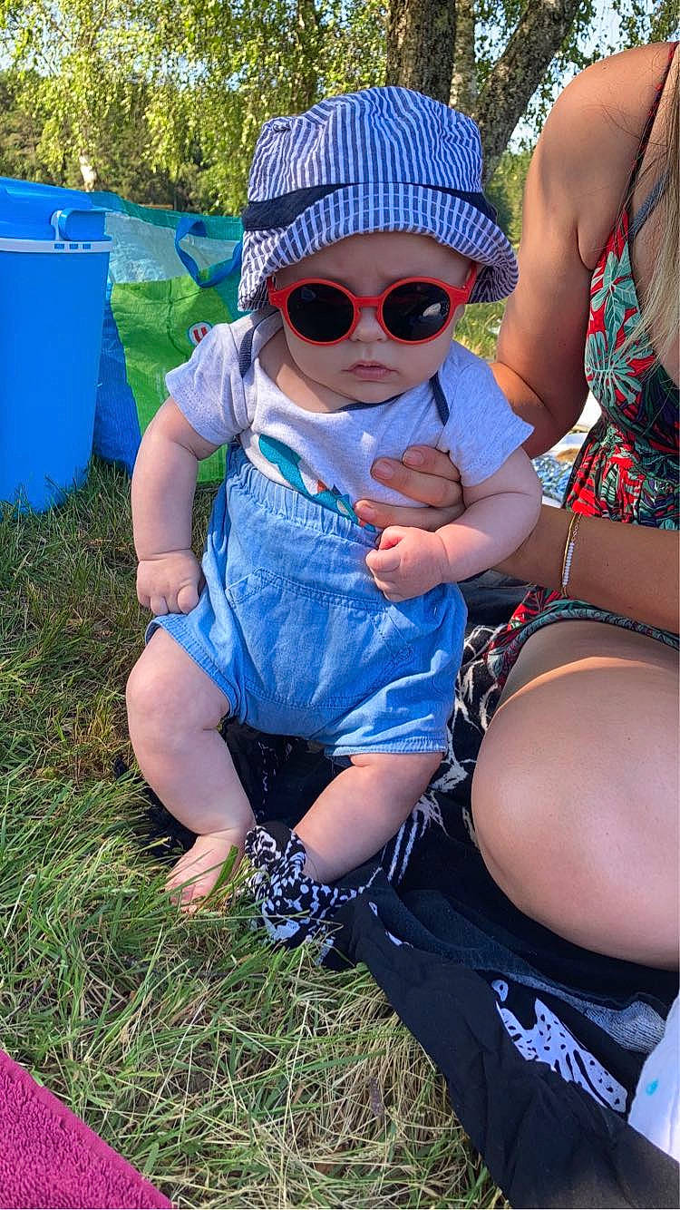 Achille a rejoint le concours — aidez-le/la à gagner de superbes lots ! blue, cap, eyewear, fun, glasses, goggles, grass, happy, hat, headgear, headwear, leg, leisure, people_in_nature, person, plant, recreation, sun_hat, sunglasses, thigh