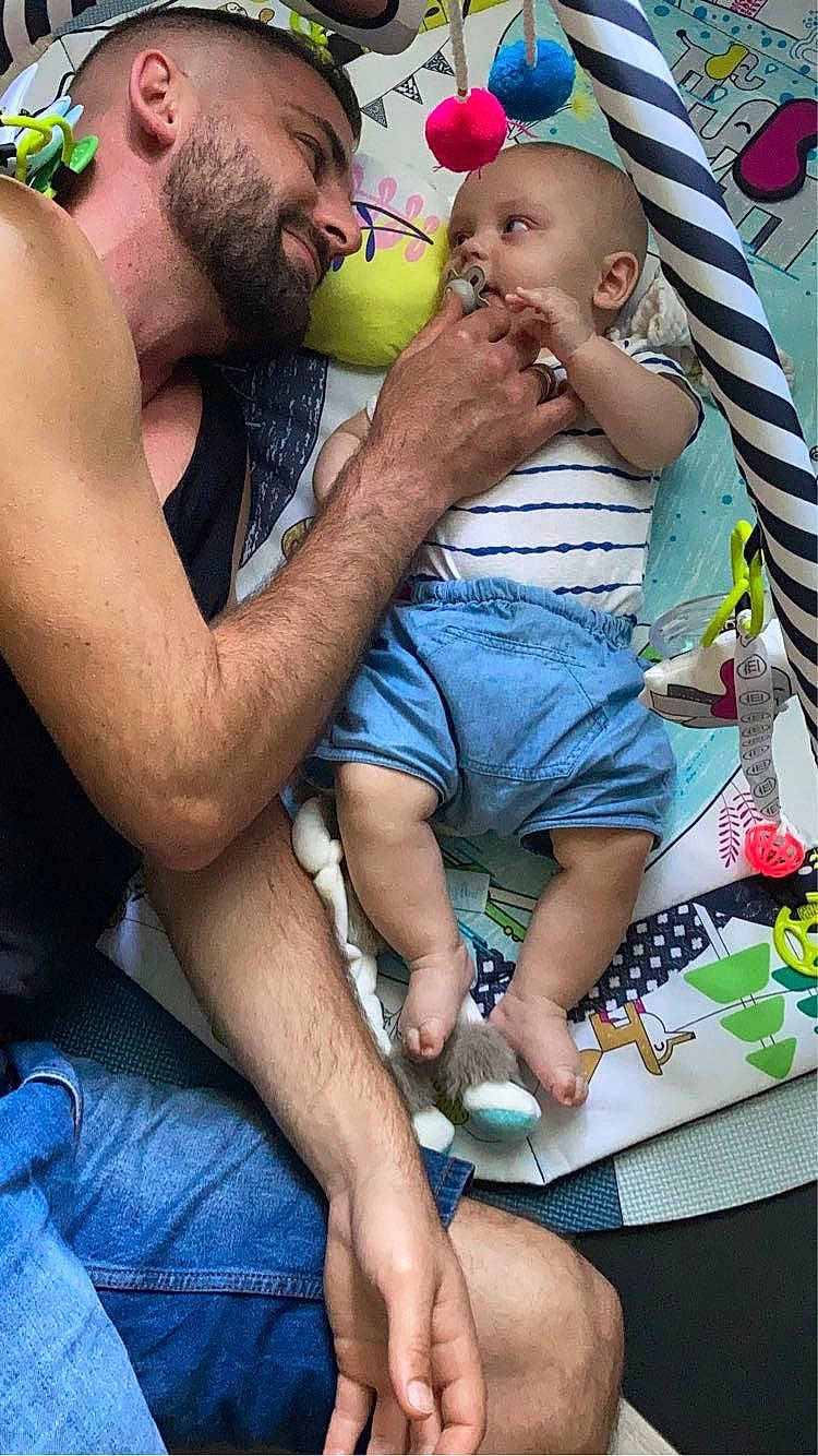 Achille participe au concours pour gagner de l'argent avec cette photo : baby, baseball_cap, beard, blue, cap, chest, child, event, facial_hair, fun, green, happy, lap, leisure, person, recreation, shorts, summer, t_shirt, thigh