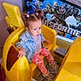 Lucia participe au concours pour gagner de l'argent avec cette photo : toddler, child, yellow_car, denim_jacket, pink_camo_pants, pigtails, hair_ties, indoor, ride_on_toy, footwear, transformers_poster, metal_floor, pink, blue_eyes, casual_clothing, expression, seat, toy_ride, wall, portrait