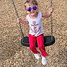casual, chain, child, cute, footwear, fun, happy, heart_shaped_sunglasses, outdoor, person, play, playground, portrait, red_pants, smiling, summer_clothing, sunlight, swing, white_tank_top, wood_chips