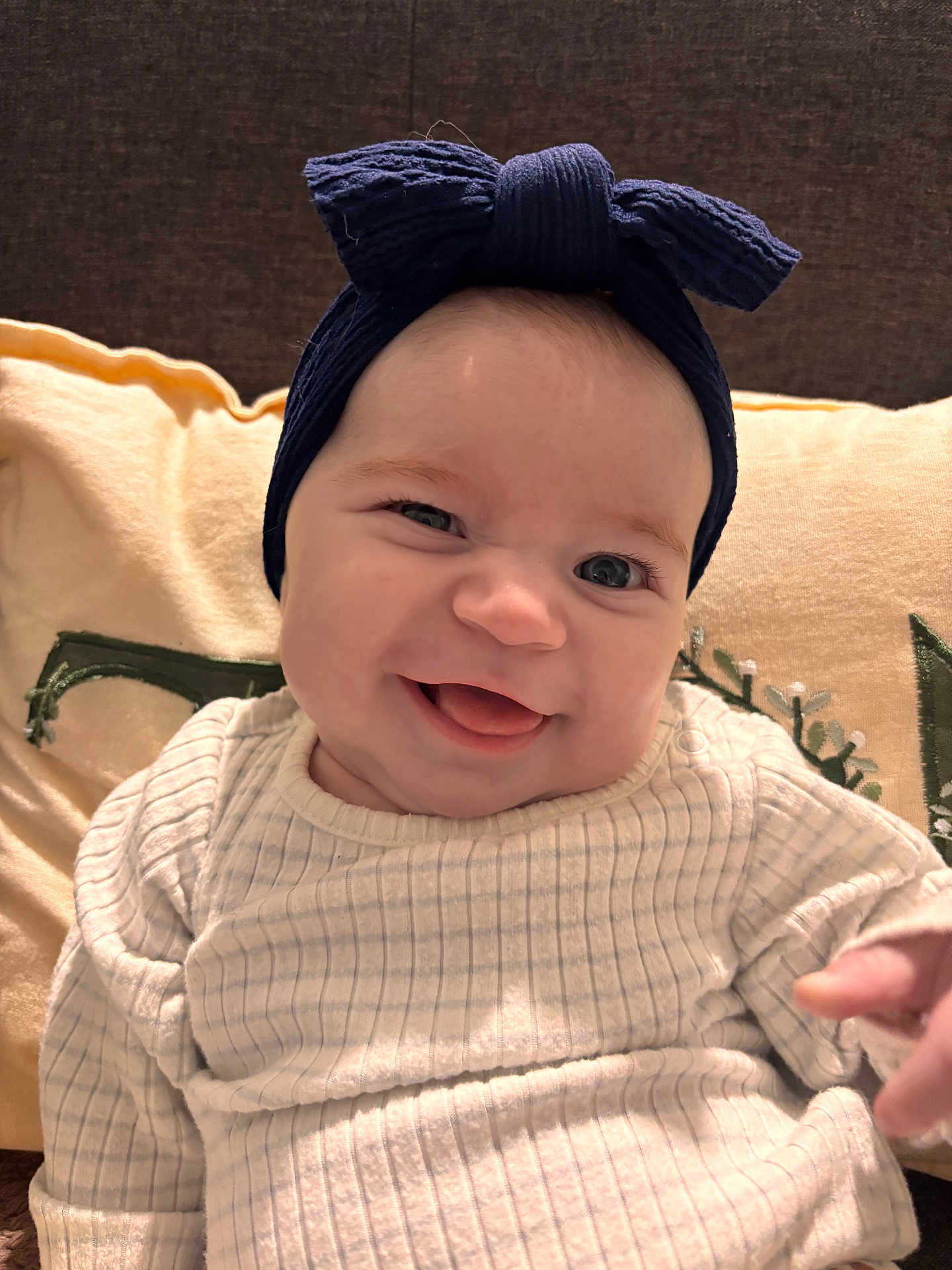 Lihana participe au concours pour gagner de l'argent avec cette photo : baby, smile, tongue, headband, bow, blue, sweater, white, pillow, beige, embroidery, face, child, happy, indoor, portrait, cute, infant, person, cozy
