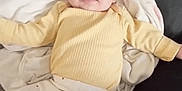 Olivia joined the competition — help win amazing prizes! baby, infant, child, yellow_clothing, white_pants, dots, blanket, cushion, black_background, smiling, tongue_out, laying_down, cute, happy, indoors, person, head, face, arms_out, soft_toys