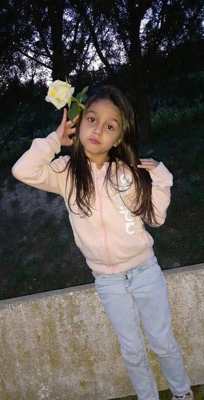 Shainna participe au concours pour gagner de l'argent avec cette photo : belt, botany, brown_hair, denim, finger, flash_photography, flower, fun, gesture, grass, happy, lip, long_hair, people_in_nature, person, petal, plant, rose, sleeve, toddler