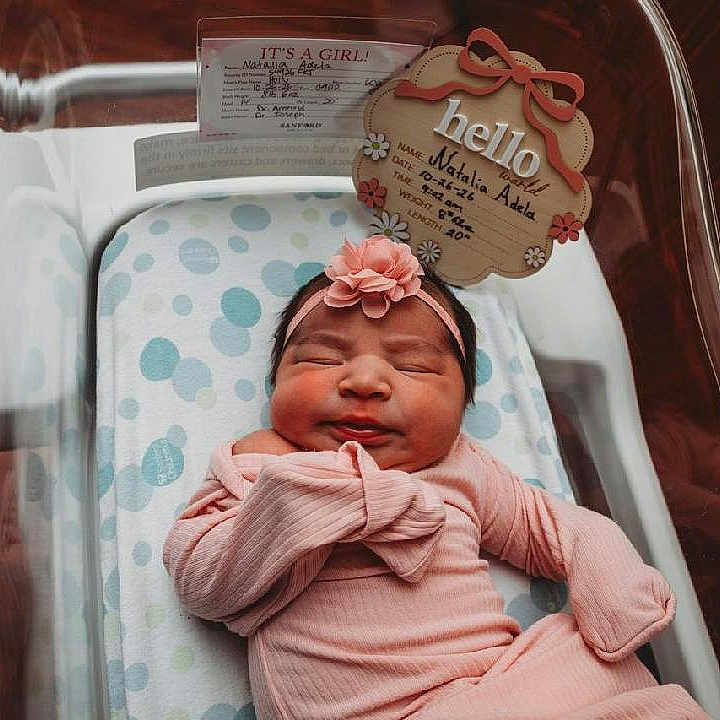 Natalia joined the competition — help win amazing prizes! newborn, baby, infant, sleeping, portrait, hospital, bassinet, pink_clothing, headband, flower, swaddled, lying_down, peaceful, nursery, birth_announcement, blanket, polka_dots, wood_floor, close_up, face