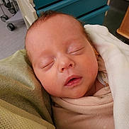 Ella joined the competition — help win amazing prizes! newborn, baby, sleeping, blanket, swaddled, face, infant, hospital, bed, soft, resting, closeup, person, head, peaceful, indoors, skin, comfort, healthcare, quiet