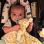 Brysen is registered to the contest to win money with this photo: baby, infant, pacifier, plush_toy, giraffe, car_seat, cushion, pattern, cloud, umbrella, child, cute, wide_eyes, hand, clothing, seatbelt, indoor, portrait, comfort, soft_toy