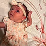 Paisley is registered to the contest to win money with this photo: baby, infant, child, headband, dress, lying_down, blanket, floral_pattern, cute, portrait, skin, face, hand, pink, peach, fabric, soft, newborn, person, indoor