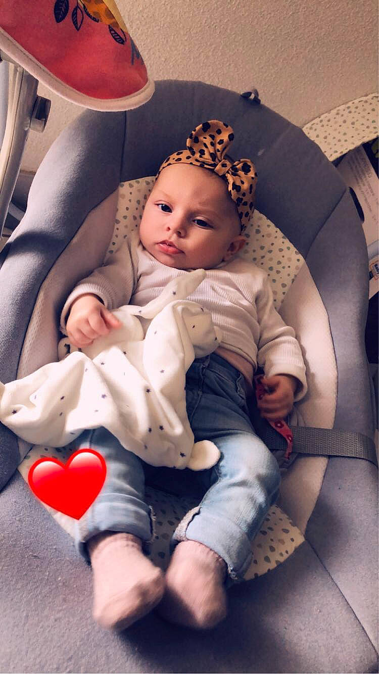 Kamelia participe au concours pour gagner de l'argent avec cette photo : baby, baby_products, baby_sleeping, baby_toddler_clothing, chair, child, comfort, dress, fashion_accessory, finger, headgear, human_leg, iris, lap, linens, mouth, person, pink, sitting, skin