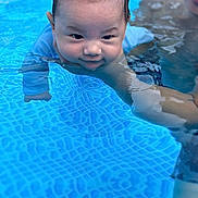Vincent joined the competition — help win amazing prizes! baby, child, water, pool, swimming, person, adult, blue, skin, face, hand, smile, summer, fun, outdoor, closeup, support, splash, wet, recreation