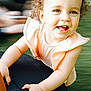 Emelia participe au concours pour gagner de l'argent avec cette photo : child, toddler, smile, curly_hair, peach_outfit, happy, face, hand, chair, black_chair, indoors, portrait, cute, baby, young_child, person, skin, eyes, expression, close_up