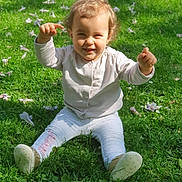 Emelia a rejoint le concours — aidez-le/la à gagner de superbes lots ! toddler, child, grass, outdoor, sunlight, greenery, flowers, happy, smiling, nature, baby, sitting, playful, casual_clothing, shoes, daylight, cute, young_child, portrait, cheerful