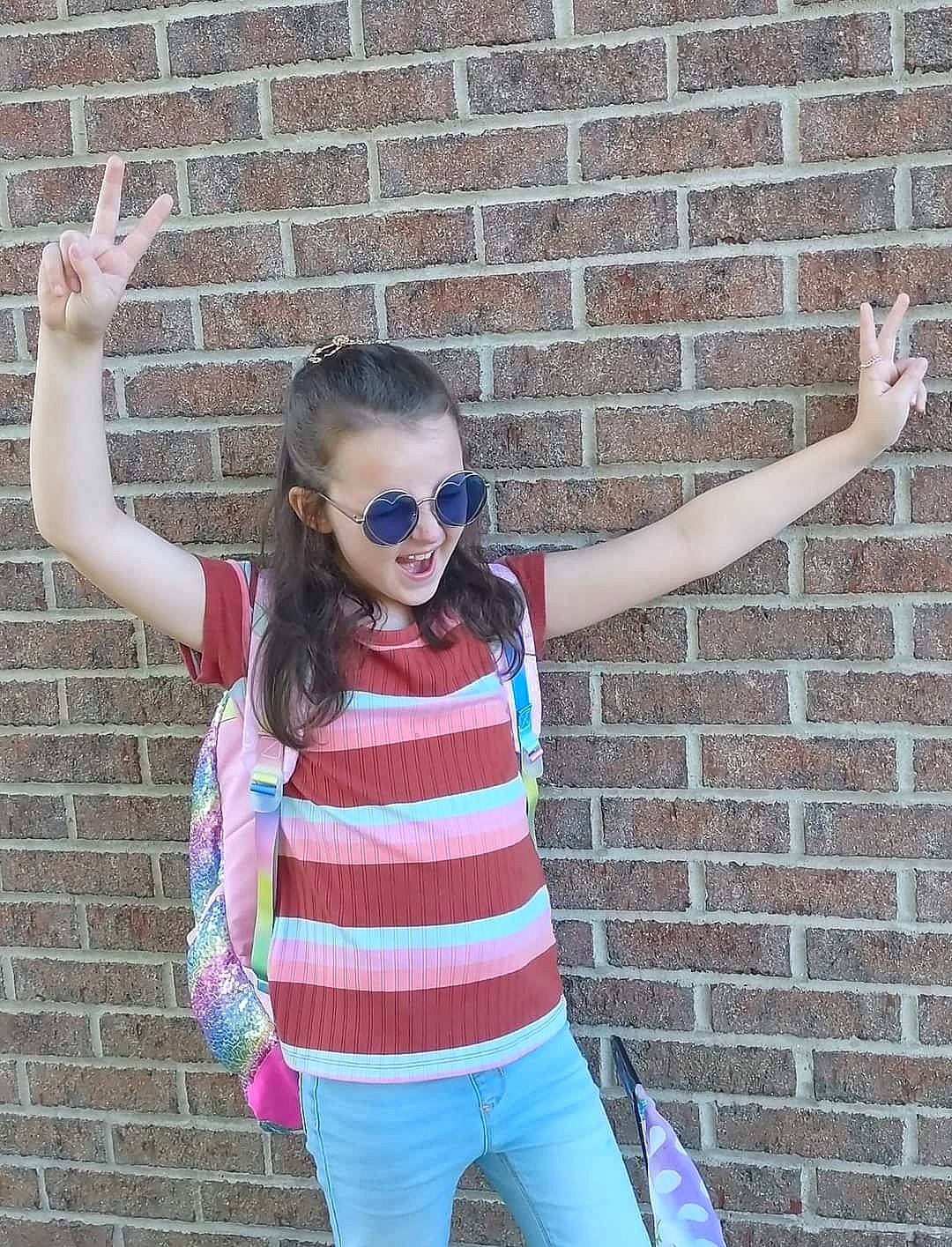 Kaylynn is registered to the contest to win money with this photo: beauty, brick, brickwork, cool, eyewear, finger, gesture, glasses, goggles, hand, happy, head, person, photograph, pink, sleeve, sunglasses, t_shirt, vision_care, waist