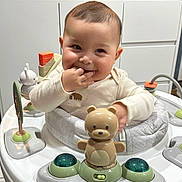 Emilio joined the competition — help win amazing prizes! activity_center, baby, bear_toy, cabinet, child, cute, fingers_in_mouth, floor, flower_vase, happy, home, indoor, infant, kitchen, microwave, play, seat, smiling, toys, white_clothing