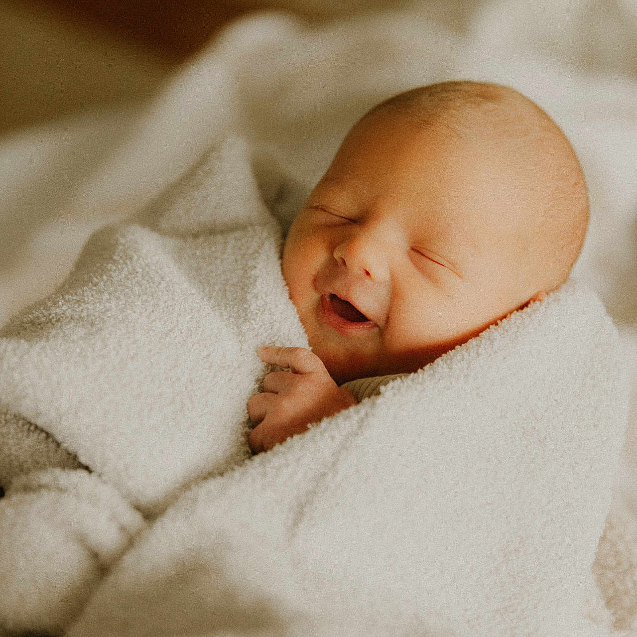Cohen is registered to the contest to win money with this photo: baby, blanket, face, happy, head, newborn, person, photography, portrait, quilt, sleeping, smile, towel