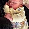 baby, newborn, sleeping, infant, yellow_clothing, animal_print, soft_texture, hand, face, peaceful, cradled, closeup, cute, indoors, resting, portrait, child, skin, head, cozy