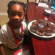 Brandon joined the competition — help win amazing prizes! birthday, birthday_badge, cake, celebration, chair, child, chocolate, cupcakes, dessert, dining_room, food, indoor, number_five, party, plate, portrait, short_hair, smiling, table, white_shirt
