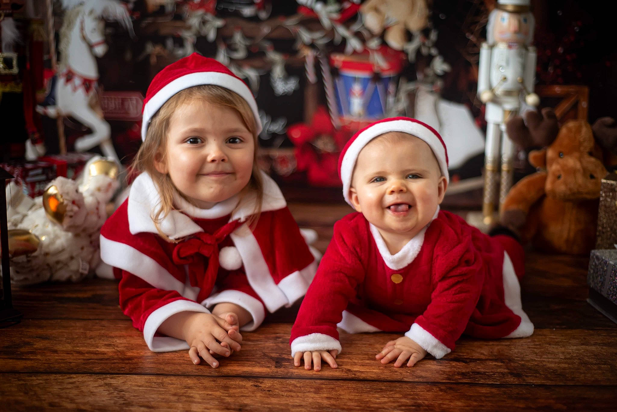 Abby a rejoint le concours — aidez-le/la à gagner de superbes lots ! baby, child, christmas, christmas_eve, christmas_ornament, event, flooring, fun, grass, happy, hardwood, headwear, holiday, joy, people, person, santa_claus, sitting, smile, toddler