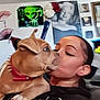 person, dog, puppy, kiss, indoor, wall_art, alien_poster, marilyn_monroe, collar, spiked_collar, black_clothing, portrait, cute, affection, pet, face, head, love, home, animal